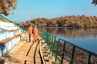 Perak, Malezya. 05.2025 Ocak: Kampong Sitiawan plaj parkındaki korkuluk şeridi boyunca yürüyen bir çiftin kızılötesi görüntüsü.