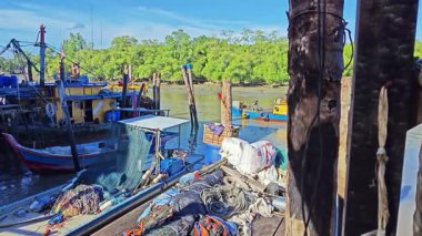 Perak, Malezya. 25 Şubat 2025: Balıkçı köyü halkının balıkçı limanı güvertesi çevresindeki faaliyetleri ve Pantai Remis balıkçı limanındaki sulak pazar.  