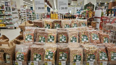Perak, Malezya. 1.2025 Mart: Aeon Sri Manjung Süpermarketindeki alışveriş merkezinde dağıtım ve satış için raflara plastik paketlenmiş fındık çeşitleri.