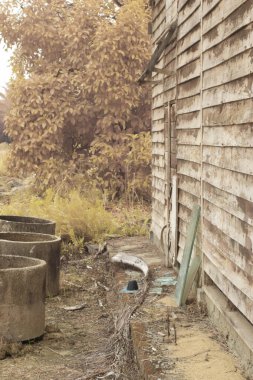 İzole edilmiş çiftlikteki terk edilmiş ve harap olmuş ahşap evin çevresindeki olay yerinin kızılötesi görüntüsü.