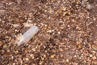 Infrared image of the landfill site with rusted and decayed bottle caps on the ground.