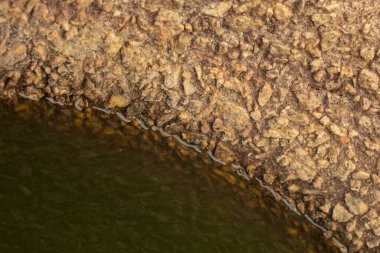 Infrared image of the cylindrical well made of granite stone wall texture.