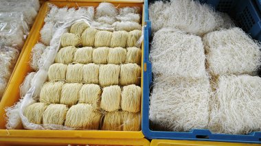 Tepside çeşitli kurutulmuş pirinç vermicelli erişteleri var..