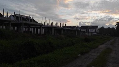 Banliyö yerleşim alanının varoşlarında yeni bir günün şafağına bakıyorum..