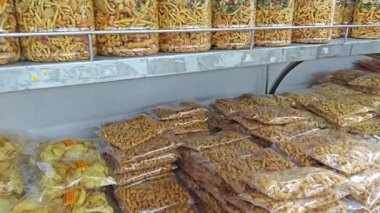 Perak, Malezya. 25 Nisan 2025: Bentong Murukku mağazasında satılık plastik paketler ve şişelerde kızartılmış ve çıtır çıtır Malezya Hindistanı abur cuburlarının çeşitliliği, Ipoh.
