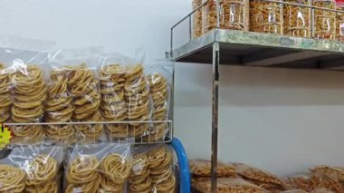 Perak, Malezya. 25 Nisan 2025: Bentong Murukku mağazasında satılık plastik paketler ve şişelerde kızartılmış ve çıtır çıtır Malezya Hindistanı abur cuburlarının çeşitliliği, Ipoh.