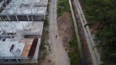 Hava görüntülerini alan adam hala inşaat halindeki boş arazide duruyor..  