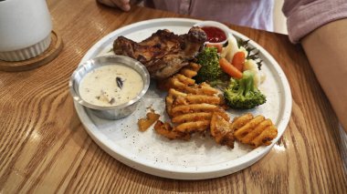 Bir tabak ızgara tavuk pirzolası, sebze ve mantar peyniri..