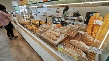 Perak, Malezya. 18 Mayıs 2025: Sitiawan 'daki Yiho pastanesi ve kafe dükkanındaki cam raflarda çeşitli pasta, ekmek ve hamur işleri sergileniyor ve satılıyor.