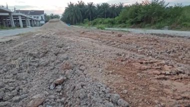 Kirli yolun yüzeyinde bilinmeyen araç tekerlek izleri var..