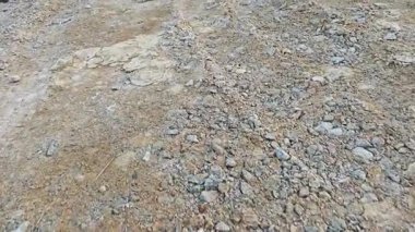 Kirli yolun yüzeyinde bilinmeyen araç tekerlek izleri var..