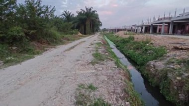 Şafak vakti güzel gökyüzü inşaat alanındaki dar kanalizasyon yolu boyunca. 
