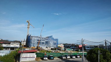 Perak, Malezya. 16 Mayıs 2025: Güzel mavi bulutlu gökyüzü ve arka planında inşaat vinci olan Looking Good Yoğun Caddesi, Kg Koh.