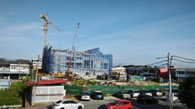 Perak, Malezya. 16 Mayıs 2025: Güzel mavi bulutlu gökyüzü ve arka planında inşaat vinci olan Looking Good Yoğun Caddesi, Kg Koh.