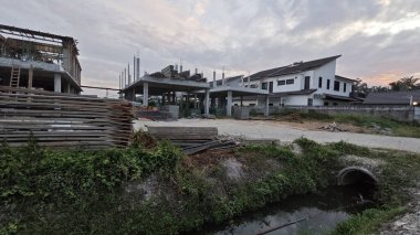 Şafak vakti güzel gökyüzü inşaat alanındaki dar kanalizasyon yolu boyunca. 