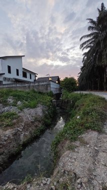 Şafak vakti güzel gökyüzü inşaat alanındaki dar kanalizasyon yolu boyunca. 