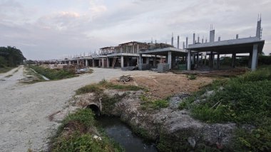 Şafak vakti güzel gökyüzü inşaat alanındaki dar kanalizasyon yolu boyunca. 