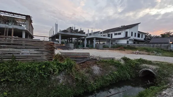 Şafak vakti güzel gökyüzü inşaat alanındaki dar kanalizasyon yolu boyunca. 