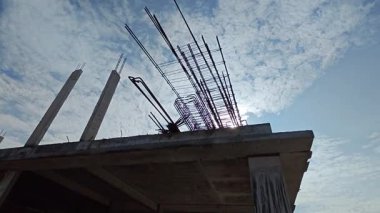 Perak, Malezya. 21 Haziran 2025: Taman Indah Permai şantiyesindeki inşaat duvarını inşa eden ve kapalı alanda çimento ve tuğla taşıyan işçilerin görüntüleri.