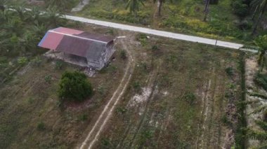 Hala yapım aşamasında olan boş arazinin etrafında insansız hava aracı uçuran bir adamın hava görüntüleri..  