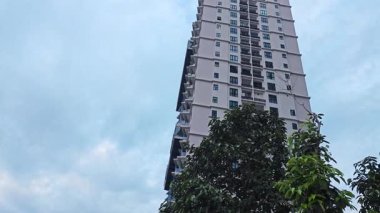 Yukarıya bakıyor mavi gökyüzünün üzerinde uçan uçakları görüyor yüksek binaların üzerinde. 