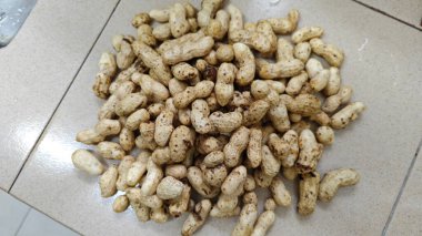 Sergilenen çiğ taze ve iyice yıkanmış fıstık yığını.