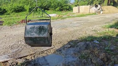 İnşaat alanındaki betonu kaldırmak için kare şeklindeki metal kovalı halat makarası..