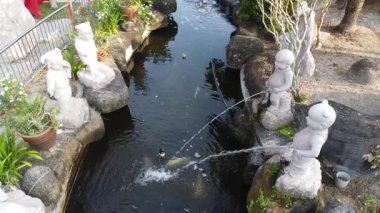 Sitiawan, Perak, Malezya. 25 Temmuz 2025: Kg Pasir Panjang, Kg koh 'taki Tua Pek Kong tapınağındaki gölete işeyen Yaramaz Nezha çeşme heykellerinin hava sahnesi.