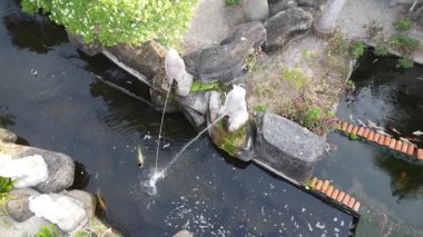 Sitiawan, Perak, Malezya. 25 Temmuz 2025: Kg Pasir Panjang, Kg koh 'taki Tua Pek Kong tapınağındaki gölete işeyen Yaramaz Nezha çeşme heykellerinin hava sahnesi.