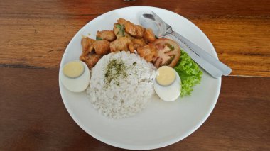 Bir tabak haşlanmış yumurta, sebze salatası ve kızarmış tatlı ekşi tavuk eti.. 