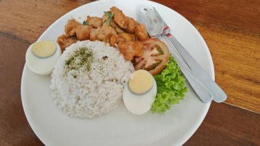 Bir tabak haşlanmış yumurta, sebze salatası ve kızarmış tatlı ekşi tavuk eti.. 