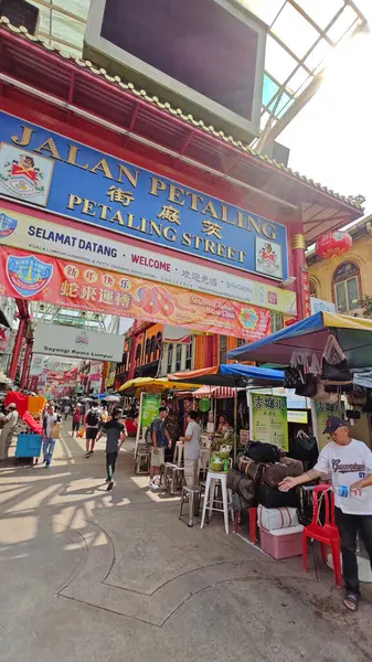 Kuala Lumpur, Malezya. 17 Temmuz 2025: Kaldırımda yürüyen ve Kuala Lumpur şehir merkezindeki işlek caddeyi keşfeden bazı turistlerin veya insanların sahnesi. 