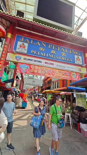 Kuala Lumpur, Malezya. 17 Temmuz 2025: Kaldırımda yürüyen ve Kuala Lumpur şehir merkezindeki işlek caddeyi keşfeden bazı turistlerin veya insanların sahnesi. 