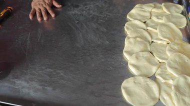 Perak, Malezya. 17 Ağustos 2025: Malezyalı bir sokak yemeği şefi, Roti Canai Sedap standında tavada ekmek pişirme konusundaki uzmanlığını gösteriyor, Kg Koh. 