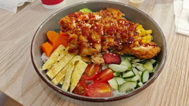 Bir kase kızarmış tavuk dürüm, dilimlenmiş omlet ve karışık sebze..