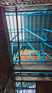 Tavan inşaatının tepesinde çatı kirişleri olan hafif alüminyum çelik kirişe bakıyorum..