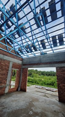 Tavan inşaatının tepesinde çatı kirişleri olan hafif alüminyum çelik kirişe bakıyorum..