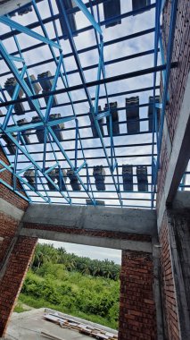 Tavan inşaatının tepesinde çatı kirişleri olan hafif alüminyum çelik kirişe bakıyorum..