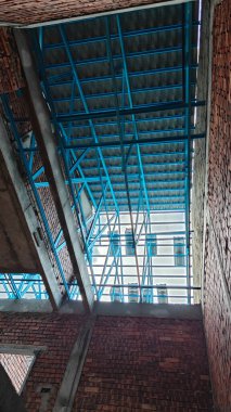 Tavan inşaatının tepesinde çatı kirişleri olan hafif alüminyum çelik kirişe bakıyorum..