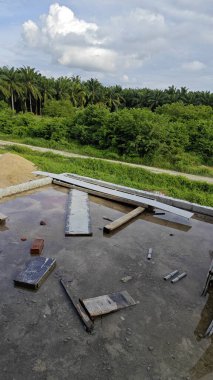 Bitmemiş inşaat binasının etrafında toplanan durgun yağmur suyu havuzu.