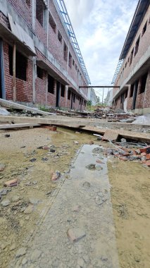 Bitmemiş inşaat binasının etrafında toplanan durgun yağmur suyu havuzu.