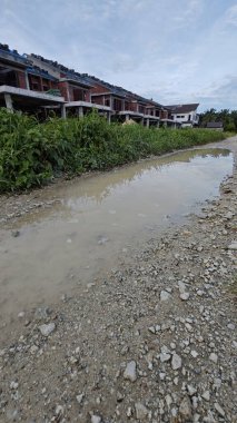 Kırsal toprak yolda sağanak yağış sonrasında durgun su havuzu yansıtıyor. 