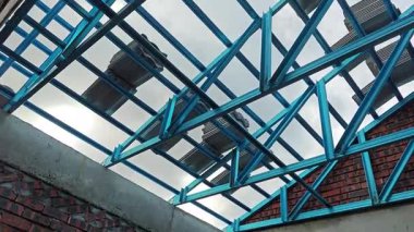 Tavan inşaatının tepesinde çatı kirişleri olan hafif alüminyum çelik kirişe bakıyorum..
