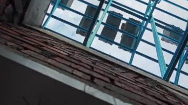 Tavan inşaatının tepesinde çatı kirişleri olan hafif alüminyum çelik kirişe bakıyorum..