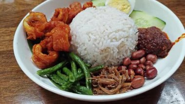 a plate of nasi lemak rice with fried slices squid dish.