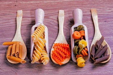 Tahta kaşıklarda çeşitli kuru makarna.