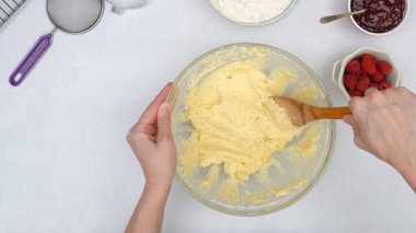 Ahududulu Noel kurabiyeleri tarifi korur. Şef cam kasede malzemeleri karıştırıyor, yukarıdan manzarayı kapat.