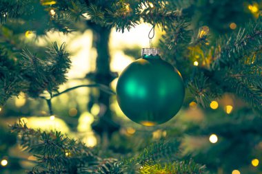 Noel ağacına asılı parlak bir Noel balosu ve şenlikli bir arka plan. Yeni yıl, Noel konsepti