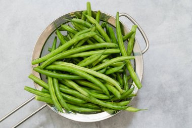 Taze taze organik fasulye, taricots verts, kevgire yakın çekim, yukarıdan görüş.