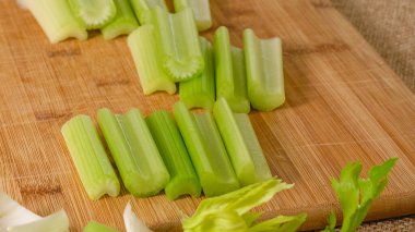 Kesme tahtasındaki taze organik yeşil kereviz. Kereviz çorbası tarifi, mutfak masasının üzerindeki malzemeler.